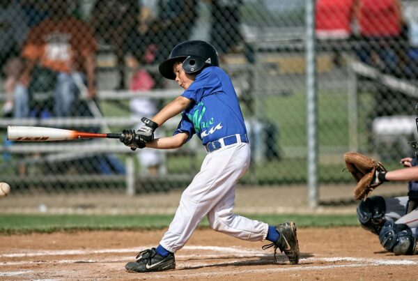 child in blue uniform batting in baseball