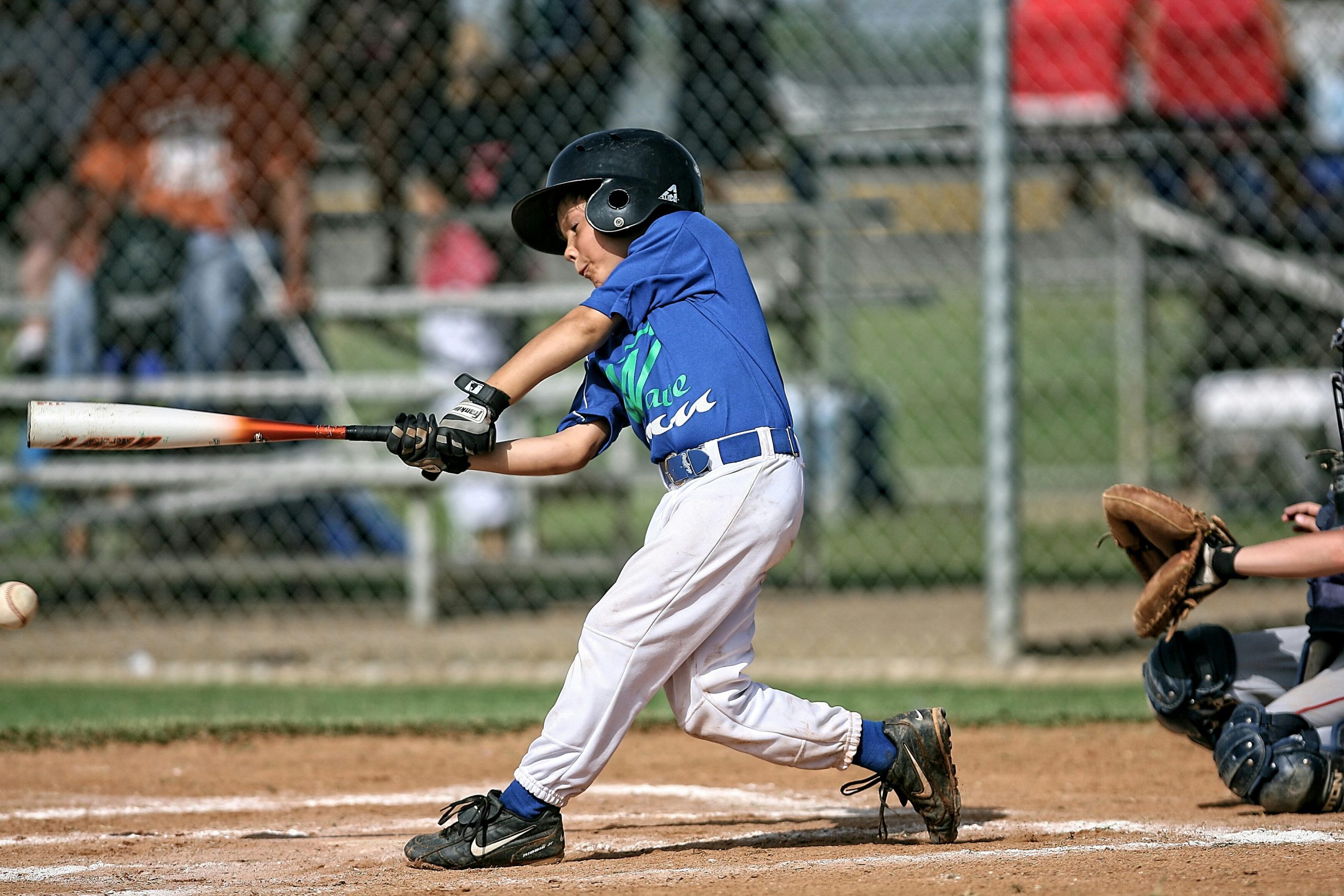 child in blue uniform batting in baseball