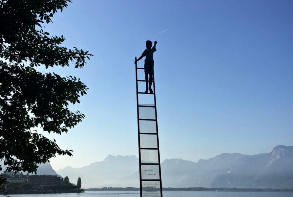 a person on a ladder in the air with blue sky