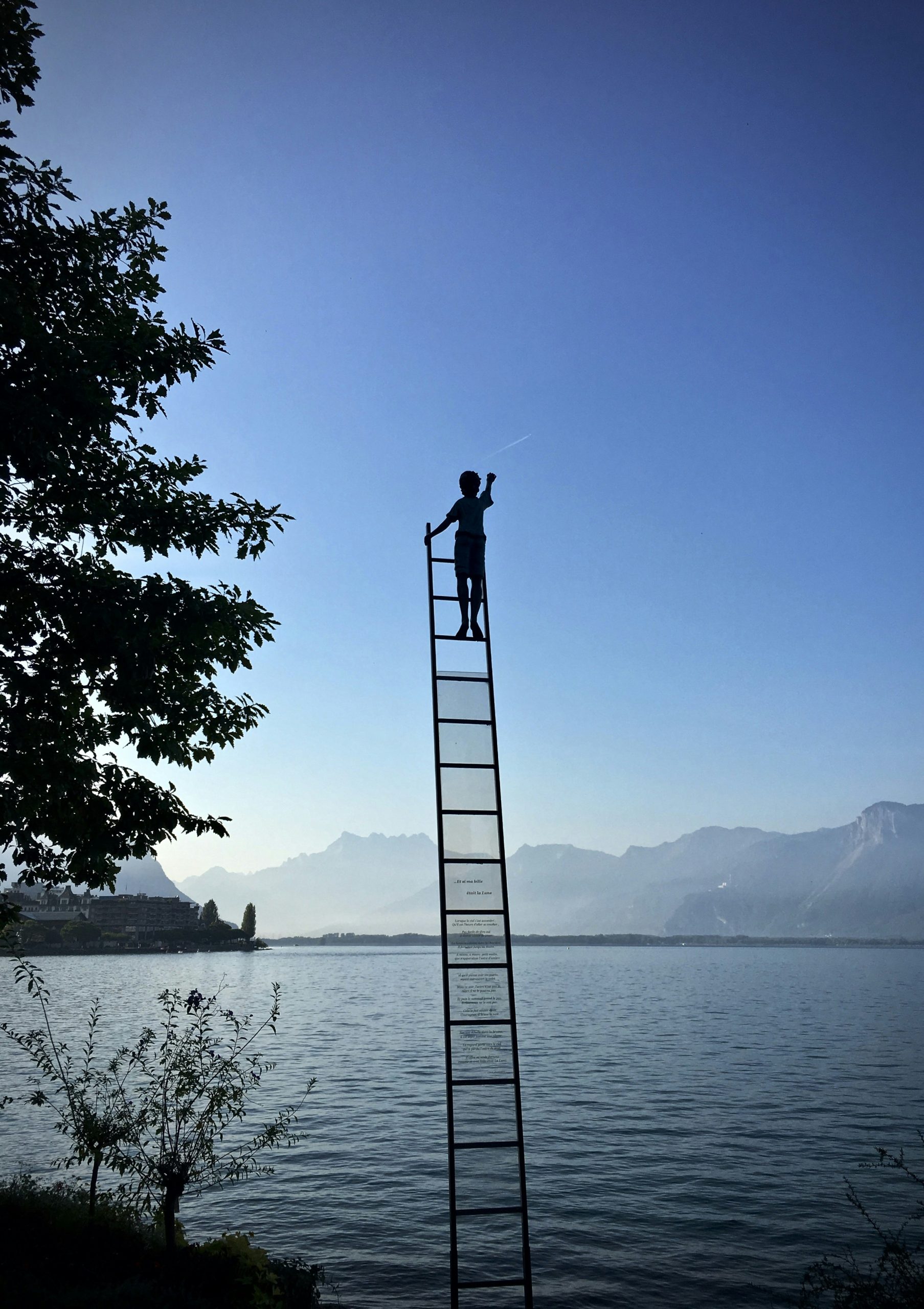 a person on a ladder in the air with blue sky